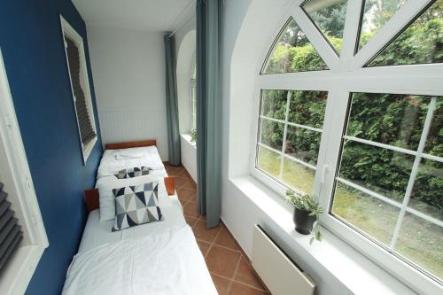 two beds in a room with two windows at Aquilo Apartmanok in Tihany