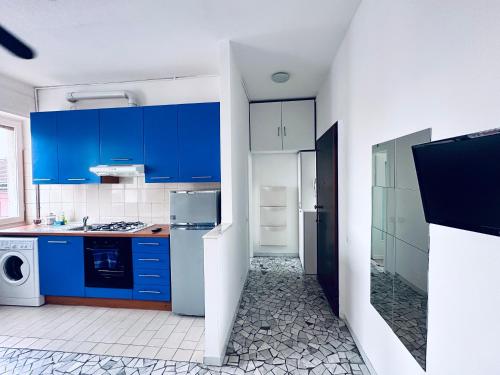 a kitchen with blue cabinets and a white refrigerator at Blue Milano in Milan