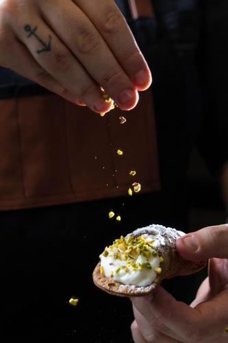 a person is sprinkling popcorn on a piece of food at Hotel Isola Sacra Rome Airport in Fiumicino