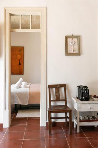 a bedroom with a bed and a chair and a table at Pátio Serrano in Rio Maior