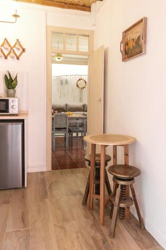 a kitchen with a table and stools in a room at Pátio Serrano in Rio Maior