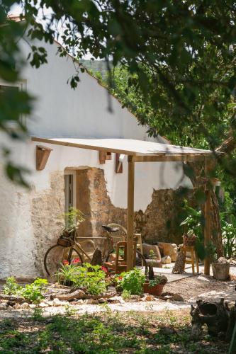 a house with a bike parked under a umbrella at Pátio Serrano in Rio Maior