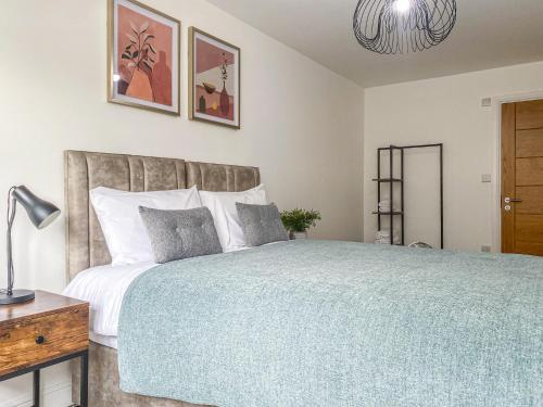 a bedroom with a large bed with a blue blanket at 2 Bedroom City Centre Apartment in High Wycombe with Parking in High Wycombe