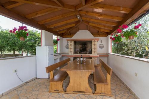 an outdoor patio with a table and a fireplace at Apartments "Alen" in Nedeščina