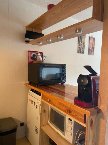 eine Küche mit einer Mikrowelle und einem TV auf der Theke in der Unterkunft Studio 28 m2 aux étoiles à La Foux Allos in Allos