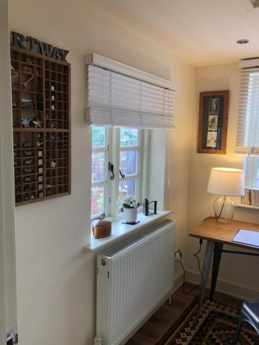 a room with a window with a radiator and a desk at Shining Star, Cartway River Views in Bridgnorth
