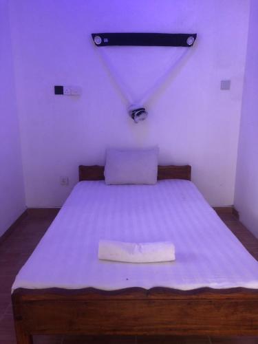 Un dormitorio con una cama con una manta azul. en Sha Place, en Weligama