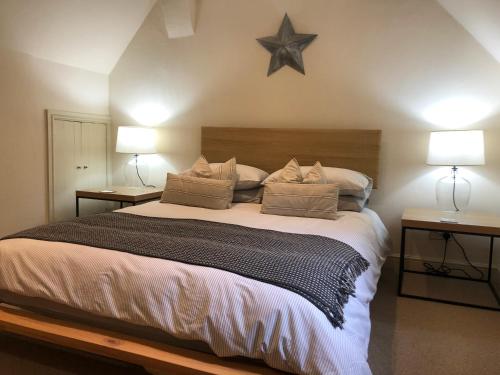 a bedroom with a large bed with two lamps and a star on the wall at Shining Star, Cartway River Views in Bridgnorth