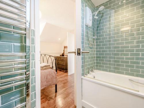 a bathroom with a tub and a sink at The Hayloft in Tenby