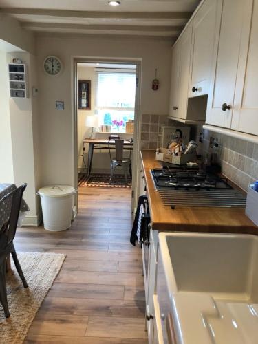 a kitchen with white cabinets and a wooden floor at Shining Star, Cartway River Views in Bridgnorth