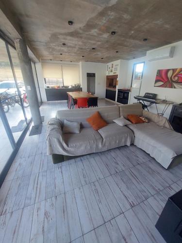 Una sala de estar con un sofá grande y una mesa. en El quincheto, en Salta