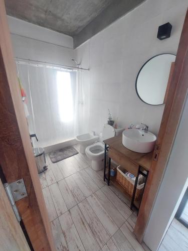 Un baño con lavabo, inodoro y espejo. en El quincheto, en Salta