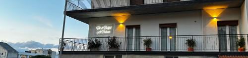 a white building with potted plants on a balcony at Bed and Breakfast Al Portanova in Reggio Calabria