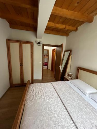 a large bed in a room with wooden ceilings at Villa Molla in Theth