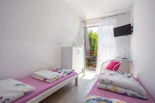 ミエルノにあるPokoje u Kasiの小さなベッドルーム(ベッド2台、窓付)