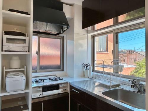 uma cozinha com um lavatório, um fogão e uma janela em Smart Stay Ito 201 em Ito