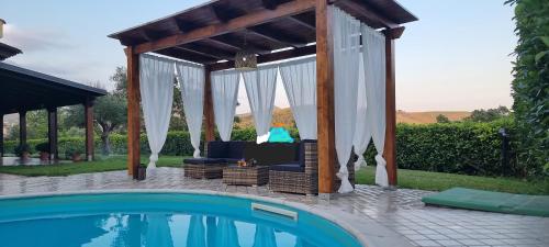 a pergola next to a swimming pool at Villa Dolce Havana con piscina in Sperlonga