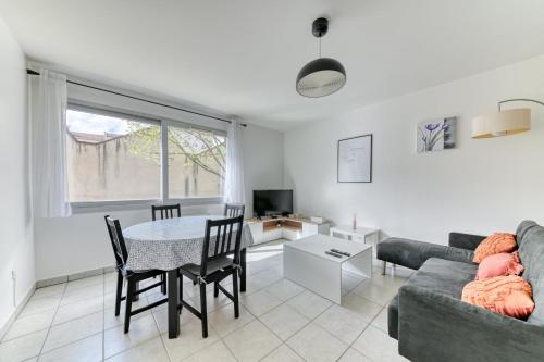 uma sala de estar com um sofá e uma mesa em Appartement Résidence Quartier Vilette Paul Bert BOX GARAGE em Lyon