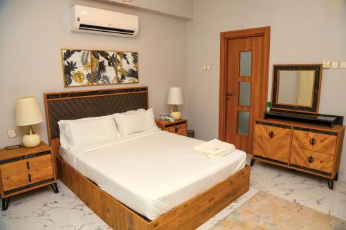 a bedroom with a bed and a dresser and a mirror at AECO lovely 2 bedroom apartment for family and friends in Muscat