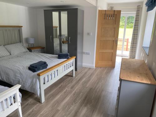 a bedroom with a bed and a wooden floor at Barn conversion in Perranwell