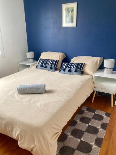 - un grand lit dans une chambre dotée d'un mur bleu dans l'établissement Nice house, garden and BBQ 3km from the beach / Jolie maison, jardin et BBQ à 3 km de la plage, à Coudekerque-Branche