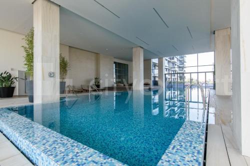 a large swimming pool with blue water in a building at Queen 4 in Belgrade