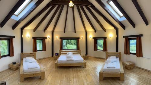 a room with two beds in it with windows at Pensiunea Poiana Izvoarelor in Vatra Dornei