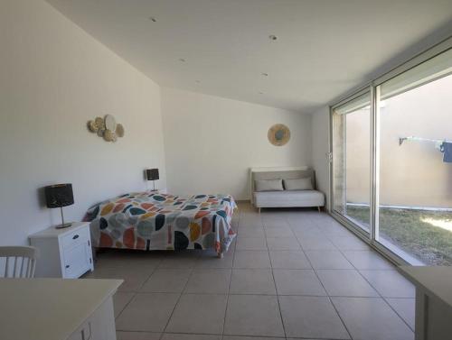 une chambre avec un lit et une grande fenêtre dans l'établissement Maison au cœur des Alpilles, à Mouriès