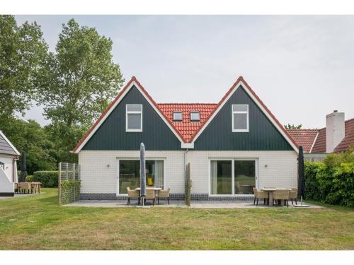 デ・カクスドルプにあるBungalow on Texel with a spacious terraceの緑屋根の大白い家
