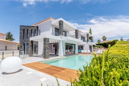 a villa with a swimming pool and a house at Villa Vogue by Indigo in Estômbar