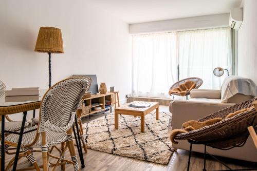 uma sala de estar com um sofá, uma mesa e cadeiras em Accès privé plage Arcachon 4pers em Arcachon