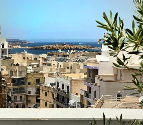 - une vue sur la ville avec ses bâtiments et l'océan dans l'établissement For Rest Aparthotel, à San Pawl il-Baħar