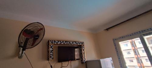 a living room with a fan and a television at شاليه فندقى للعائلات غرفة وريسيبشن بمنتجع ريتال فيو الساحل الشمالى in El Alamein