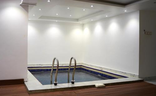 a swimming pool with two metal handles in a building at AECO lovely 2 bedroom apartment for family and friends in Muscat