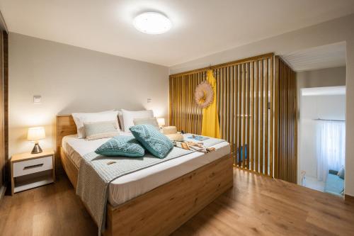 une chambre avec un grand lit avec des oreillers bleus dessus dans l'établissement Corfu Luxury Lofts by Corfuescapes, à Corfou