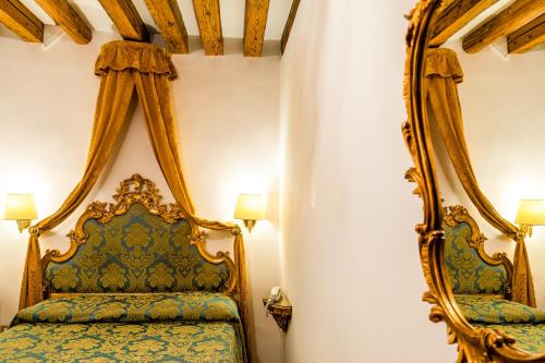 a bedroom with a canopy bed and a mirror at Hotel Al Vagon in Venice