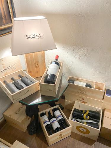 a table with boxes of wine bottles and a lamp at Hotel Baia D'Oro - Adults Only in Gargnano