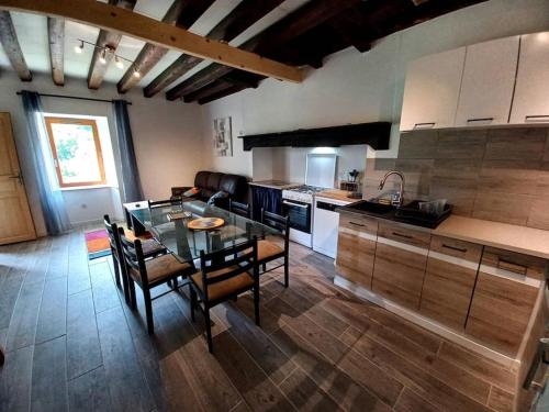 une cuisine avec une table en verre et des chaises dans une pièce dans l'établissement vue imprenable sur montagne, à Saint-Aventin