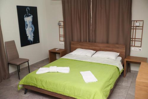 a bedroom with a green bed with two towels on it at Zeusplace Pool Villa Olympus Riviera in Litochoro