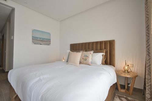 - une chambre dotée d'un grand lit avec des draps et des oreillers blancs dans l'établissement New Sea Front Apartment 135mq with Unlimited Wi-Fi, à Agadir
