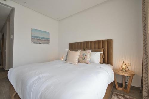a bedroom with a large bed with white sheets and pillows at New Luxury Apartment 135sqm Terrace Seafront Unlimited Wi-Fi in Agadir