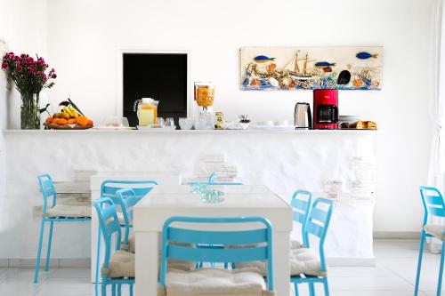 a dining room with a table and blue chairs at Hotel Opera in Larnaca