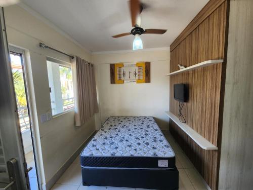 um quarto com uma cama e uma ventoinha de tecto em Lacqua diRoma 1 - Apartamentos JN em Caldas Novas