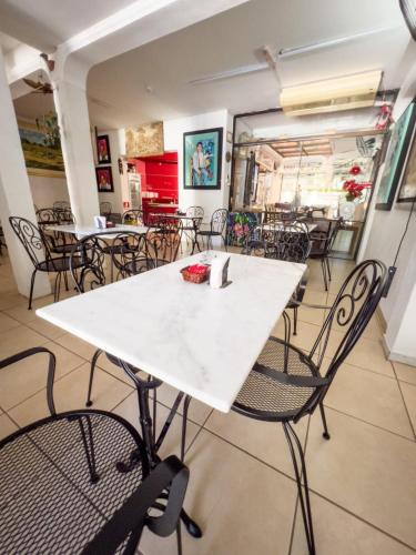 a dining room with a white table and chairs at ApartHotel Maison Suisse in Asuncion