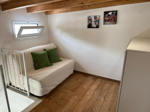 Habitación con sofá y almohadas verdes. en Borghetto Mediterraneo, en Santa Maria del Focallo