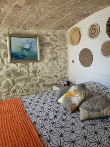 een slaapkamer met een bed in een stenen muur bij So Home in Saint-Pantaléon-les-Vignes