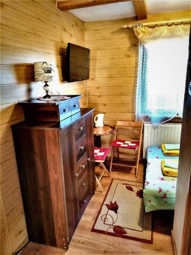 una stanza con cassettiera e televisore in una stanza di Adelka-dom przy stoku a Krynica-Zdrój