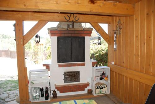an outdoor fireplace in a wooden house with a porch at Adelka-dom przy stoku in Krynica Zdrój