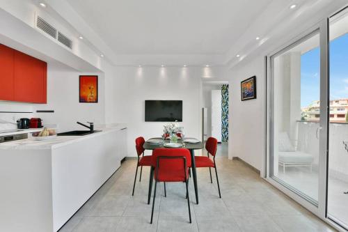 une cuisine et une salle à manger avec une table et des chaises rouges dans l'établissement CROISETTE BEACH - Modern 2 Bdrs Best Location!, à Cannes