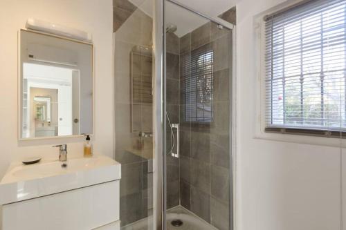 y baño con ducha, lavabo y espejo. en Studio indépendant proche Aix-en-Provence, en Châteauneuf-le-Rouge